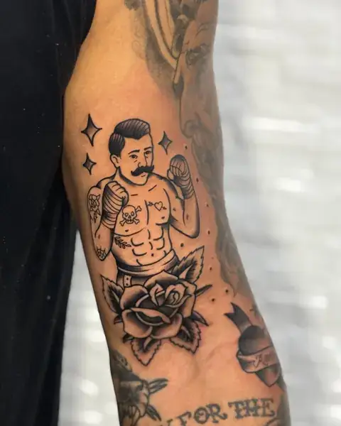 Tatuagem old school de boxeador com rosa no braço
