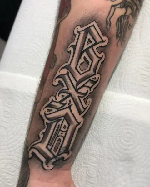 Custom lettering “BXD” em letras góticas no antebraço