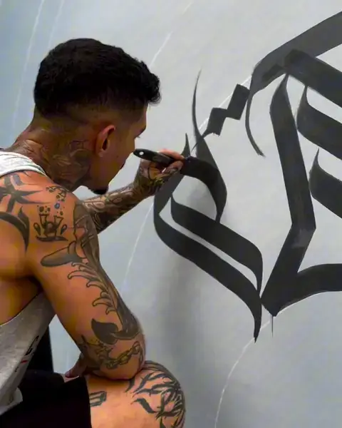 André Loureiro pintando as primeiras letras de calligraffiti na parede
