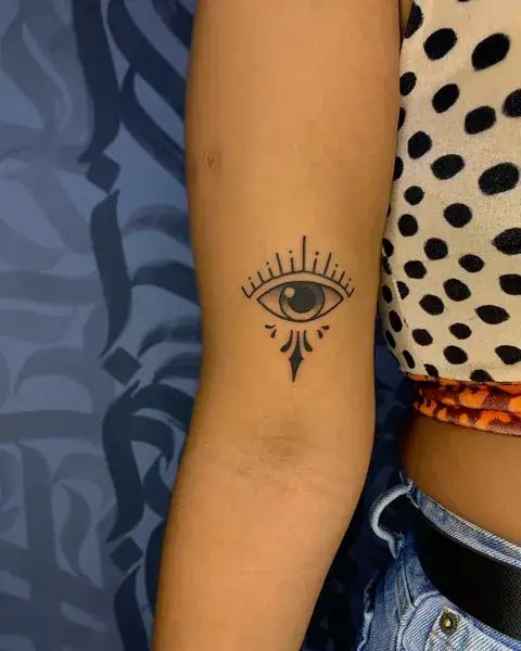 Tatuagem de olho com raios no braço